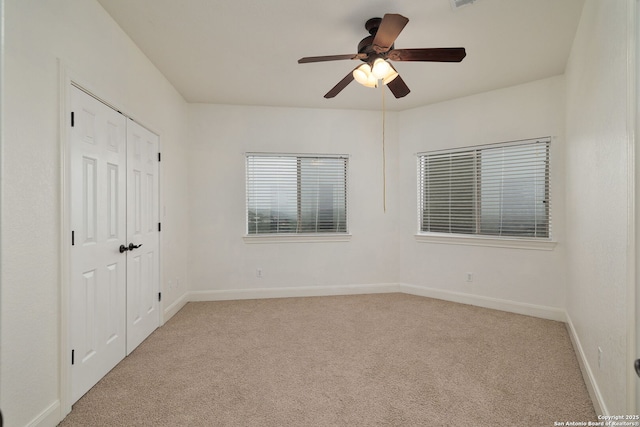 unfurnished room featuring light carpet, ceiling fan, and baseboards