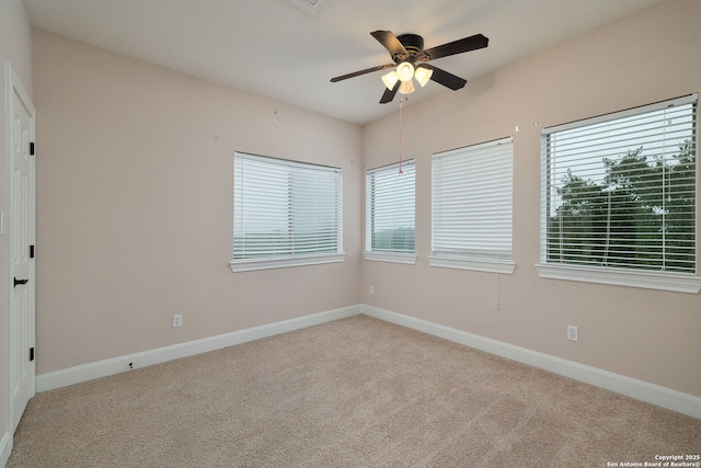 unfurnished room with baseboards, a ceiling fan, and light colored carpet