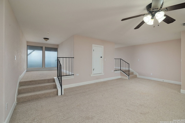 empty room featuring visible vents, baseboards, a ceiling fan, light colored carpet, and stairs