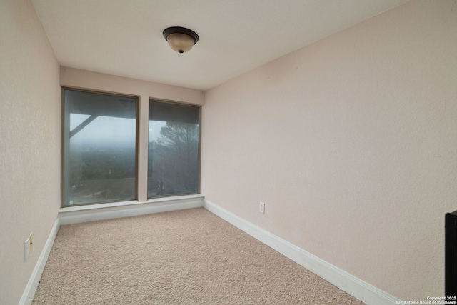 unfurnished room with carpet and baseboards