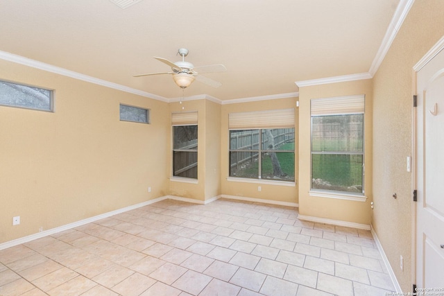 spare room with a ceiling fan, crown molding, and baseboards