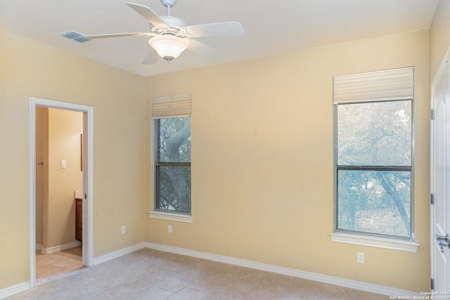 spare room featuring baseboards, visible vents, and a ceiling fan