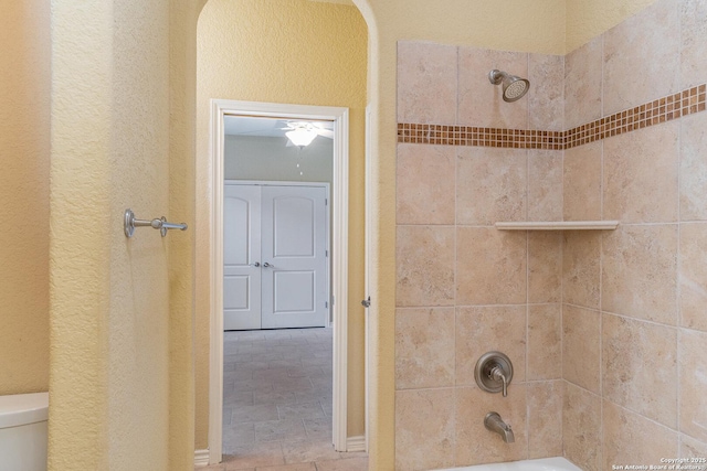 bathroom featuring shower / washtub combination and toilet