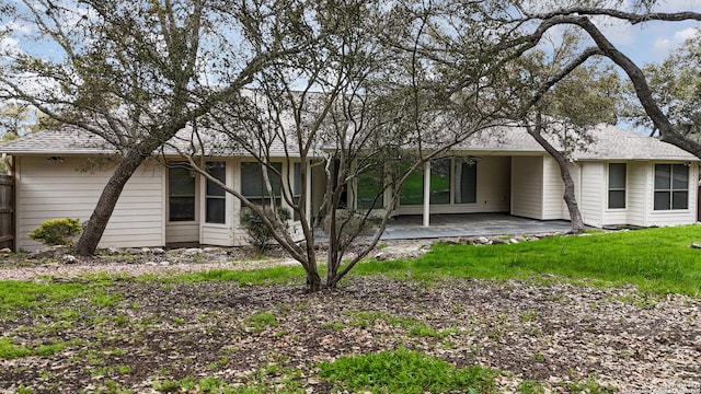 back of house with roof with shingles and a patio