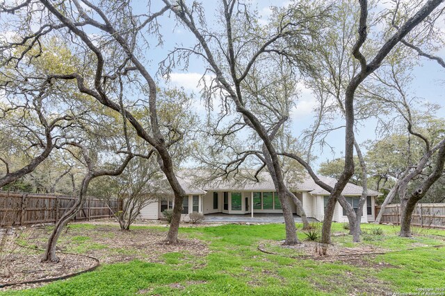 view of yard featuring a fenced backyard, a patio, and driveway