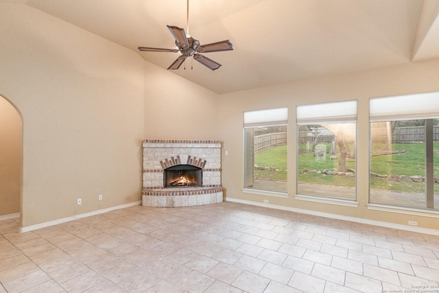 unfurnished living room featuring a fireplace, a ceiling fan, and baseboards