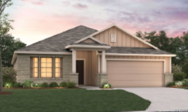 view of front of property with an attached garage, a lawn, board and batten siding, and concrete driveway