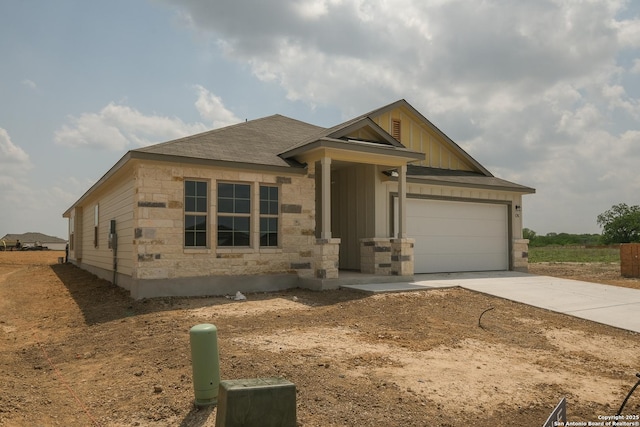 10314 Tule Creek Frk, San Antonio, TX 78252 - view of front of property with an attached garage, board and batten siding, concrete driveway, stone siding, and roof with shingles