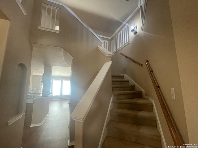 staircase with a high ceiling and wood finished floors