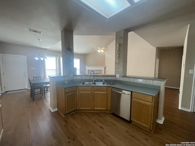 kitchen with a peninsula, a sink, visible vents, dishwasher, and decorative light fixtures