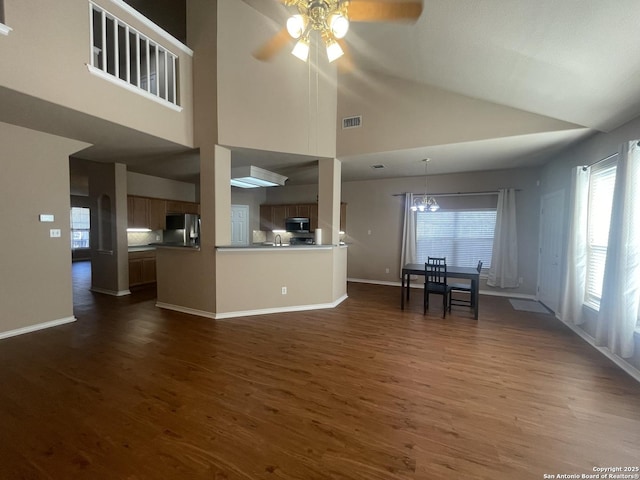 unfurnished living room with baseboards, visible vents, dark wood-style flooring, and ceiling fan with notable chandelier