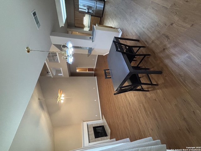 kitchen featuring dark wood-type flooring, a tile fireplace, and a towering ceiling