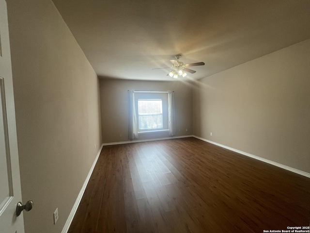 unfurnished room featuring ceiling fan, dark wood finished floors, and baseboards