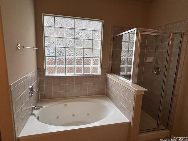 bathroom with a jetted tub and a shower stall