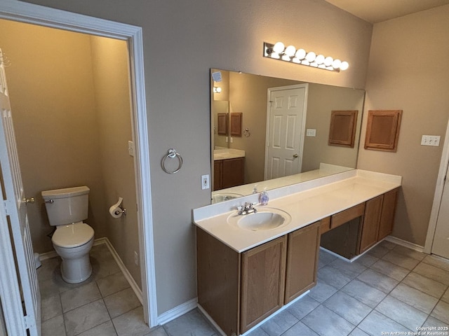 bathroom with baseboards, vanity, toilet, and tile patterned floors