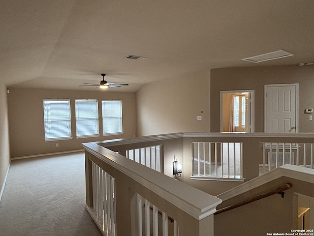 hall with baseboards, visible vents, carpet flooring, and an upstairs landing