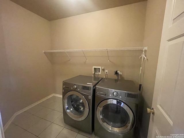 laundry area featuring laundry area, baseboards, washer and dryer, and light tile patterned flooring