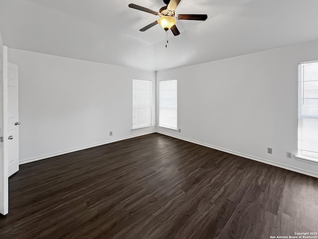 spare room with dark wood-style floors, ceiling fan, and baseboards