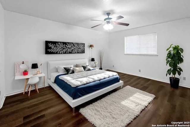 bedroom with a ceiling fan, dark wood finished floors, and baseboards