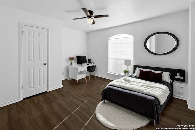 bedroom with ceiling fan, dark wood-type flooring, and baseboards