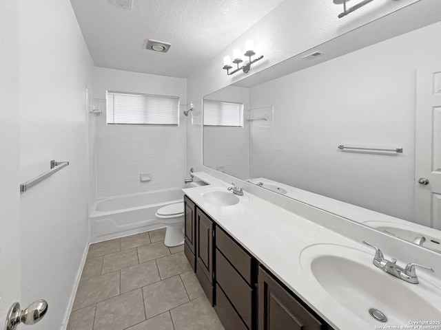 bathroom with a textured ceiling, tile patterned flooring, a sink, and toilet