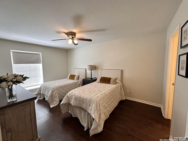 bedroom with dark wood-style floors, a textured ceiling, a ceiling fan, and baseboards