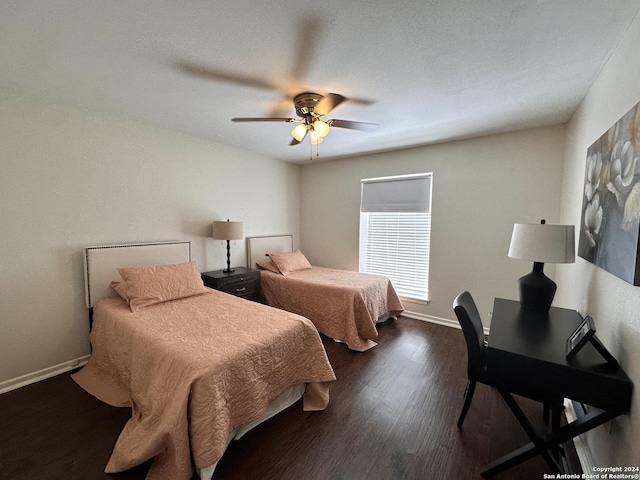 bedroom with dark wood-style flooring, a ceiling fan, and baseboards