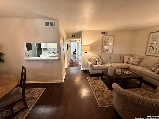 living room with baseboards, visible vents, and dark wood finished floors