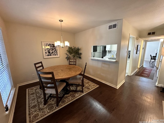 dining area with an inviting chandelier, visible vents, and dark wood-style flooring