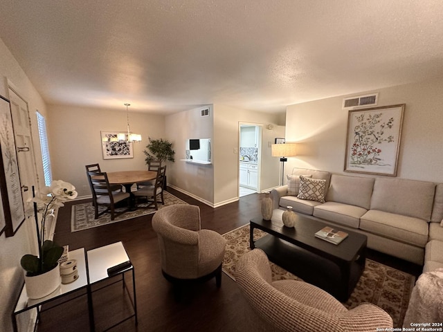 living area featuring baseboards, a textured ceiling, visible vents, and dark wood-style flooring