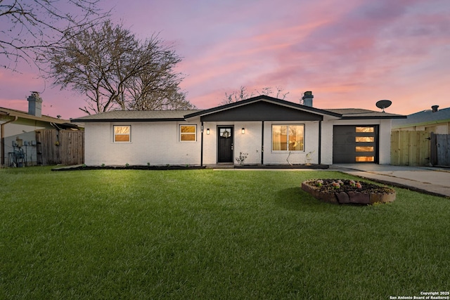 view of front of house featuring a garage, a yard, and driveway