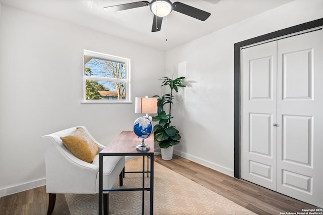 home office featuring light wood-type flooring, ceiling fan, and baseboards