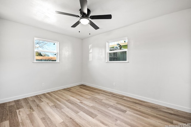 unfurnished room with light wood finished floors, a ceiling fan, a wealth of natural light, and baseboards