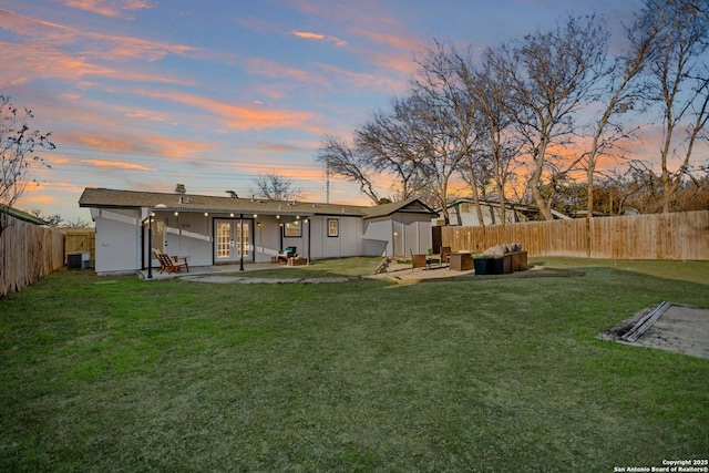 back of house at dusk featuring a yard, central air condition unit, an outdoor hangout area, a patio area, and a fenced backyard