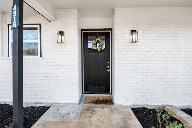 entrance to property featuring brick siding