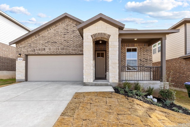 french country home with driveway, brick siding, and an attached garage