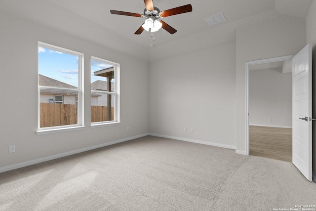 empty room featuring baseboards, visible vents, ceiling fan, and light colored carpet