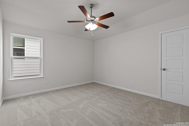 unfurnished room featuring a ceiling fan, light carpet, and baseboards