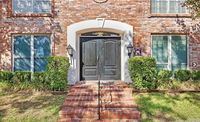 view of exterior entry with brick siding