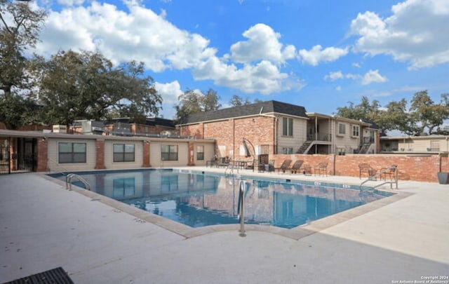 community pool featuring a patio area and fence