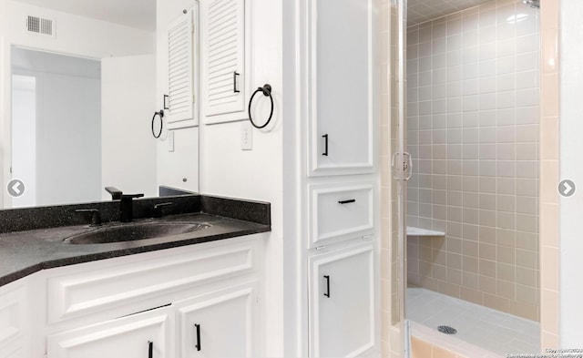 full bath featuring visible vents, vanity, and a shower stall