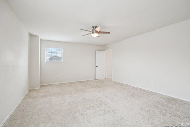 empty room with ceiling fan, baseboards, and light colored carpet