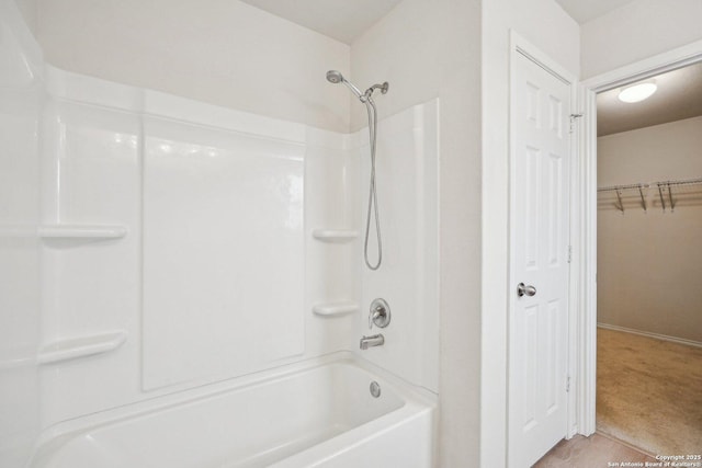 full bath featuring a walk in closet and washtub / shower combination