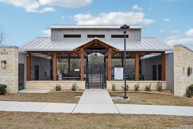 view of front of property with a standing seam roof, a fenced front yard, and metal roof