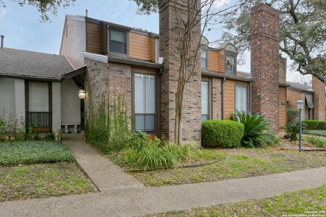 view of side of home with brick siding and a chimney