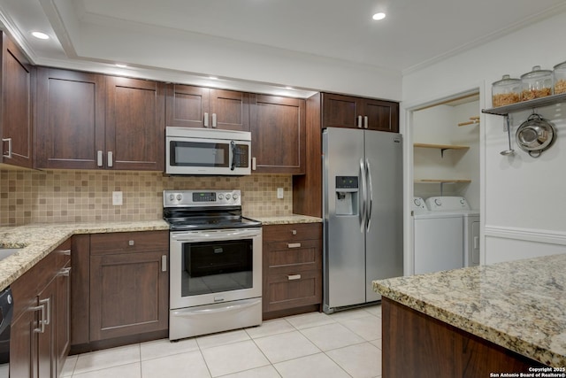 kitchen with stainless steel appliances, backsplash, ornamental molding, light tile patterned flooring, and independent washer and dryer