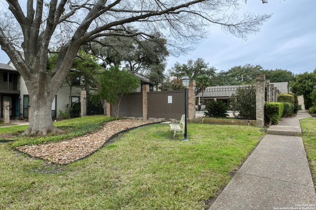 view of home's community with a yard and fence