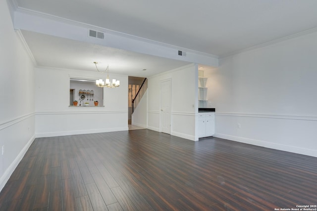 unfurnished living room with visible vents, dark wood finished floors, crown molding, and a chandelier