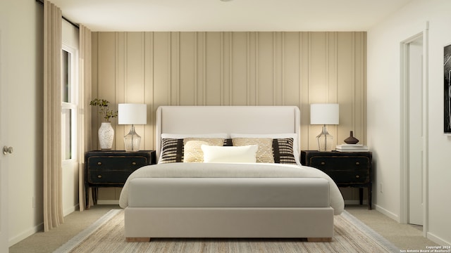 bedroom with baseboards and light colored carpet