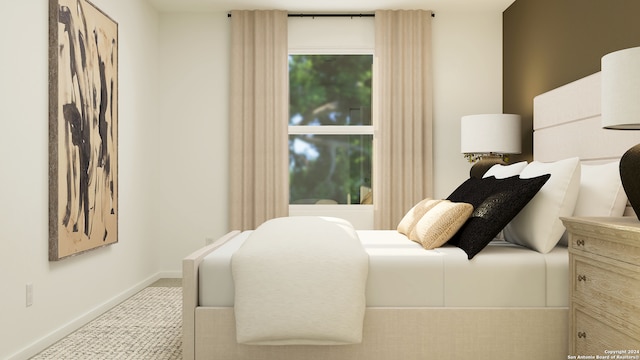 bedroom with light colored carpet and baseboards